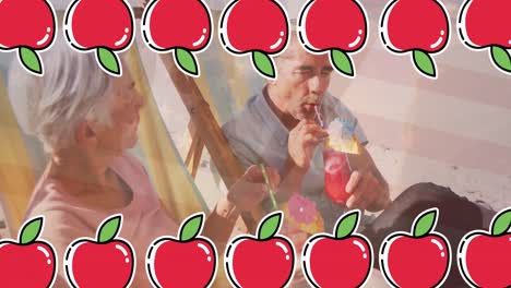 animación de iconos de manzana sobre una pareja caucásica en la playa.