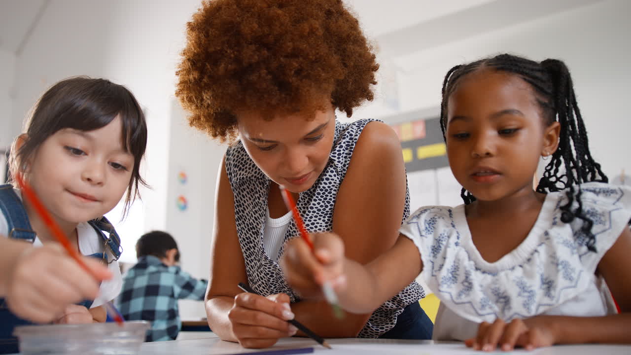 Close Up Of Female Teacher With Multi-Cultural Elementary School Pupils In Art Class