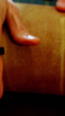 sección media de una artesana extendiendo una hoja de cuero sobre una herramienta de trabajo