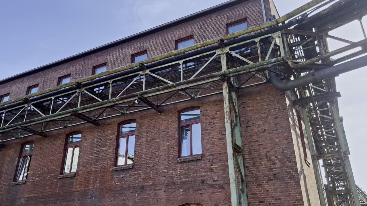 viejas tuberías de acero oxidado en un marco metálico en una casa de ladrillo en el parque paisajístico dusibrug norte de alemania, que ahora es un albergue juvenil