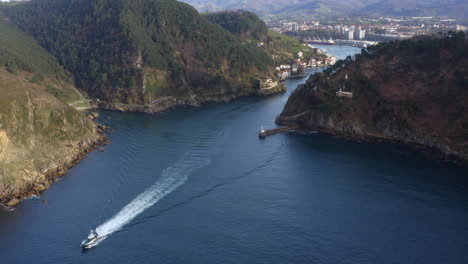 beautiful aerial view of a boat leaving pasaia bay