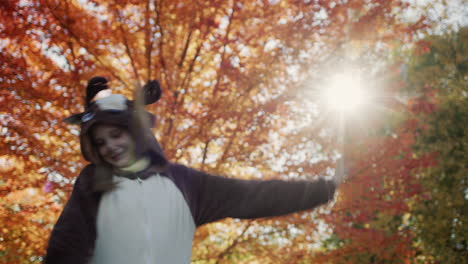 A-cheerful-child-in-a-deer-costume-dances-near-a-beautiful-autumn-tree