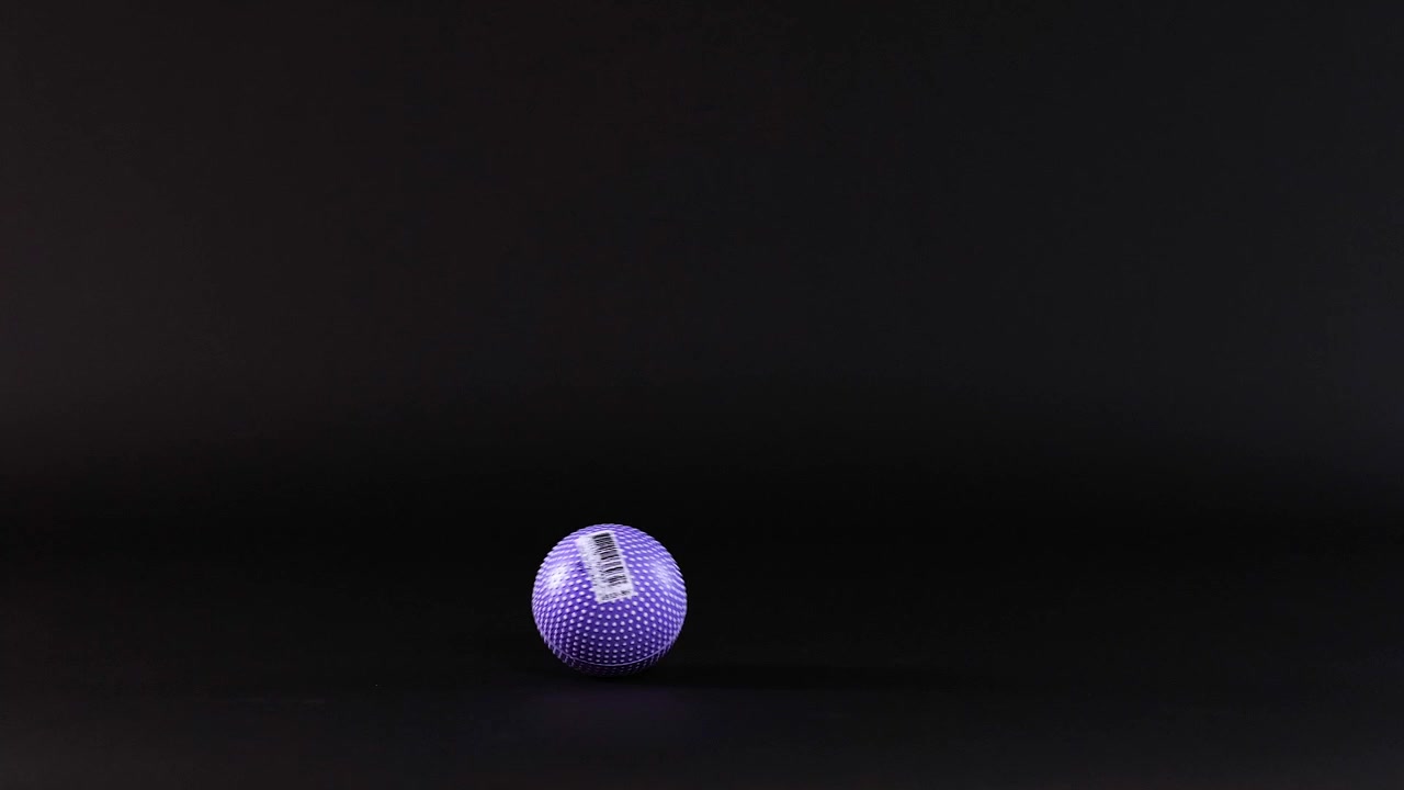 A purple ball rolls across a dark surface