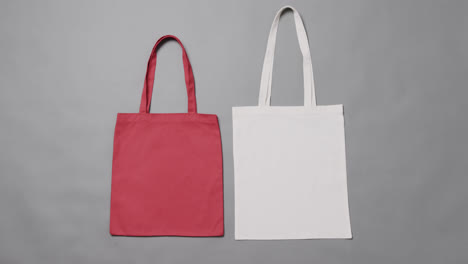 Close-up-of-red-and-white-bags-on-grey-background,-with-copy-space,-slow-motion