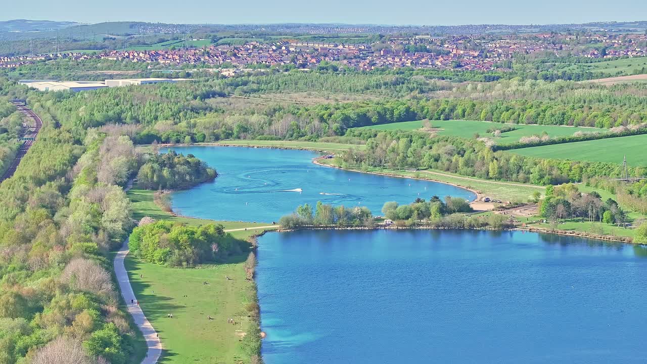 Aerial: speedboats on the lake during the day in Rother Valley Country Park in the Metropolitan Borough of Rotherham, South Yorkshire, England, crane down drone shot