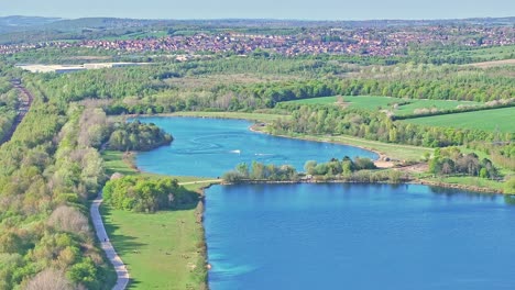 aerial: speedboats on the lake during the day in rother valley country park in the metropolitan borough of rotherham, south yorkshire, england, crane down drone shot