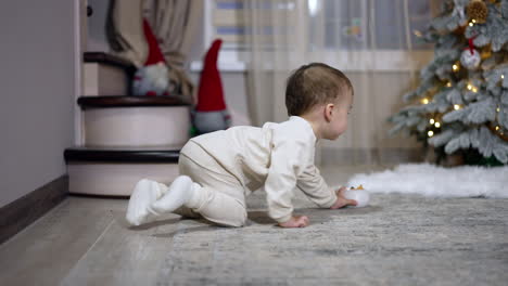 baby crawling near christmas tree