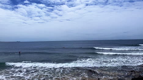 slo-mo of waves rolling in and surfers at moffat beach, sunshine coast queensland aus