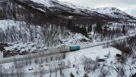 Arctic-norwegian-landscape-close-to-Narvik-establishing-shot-with-road-and-trucks-in-focus