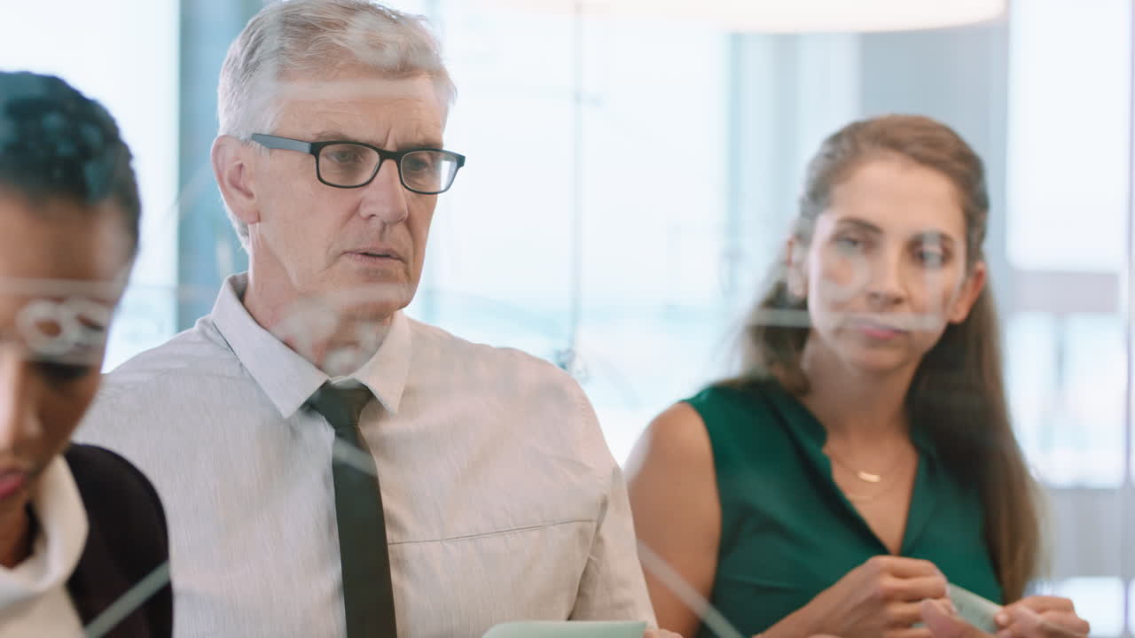 reunión de equipo de negocios utilizando notas adhesivas escribiendo en pizarra de vidrio lluvia de ideas colegas que trabajan en la estrategia de resolución de problemas pensando en la solución para el proyecto en la oficina a través del vidrio