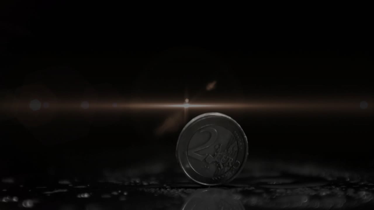 Left starburst rising causing coin rocking spinning and tilting on ground with stars and flares