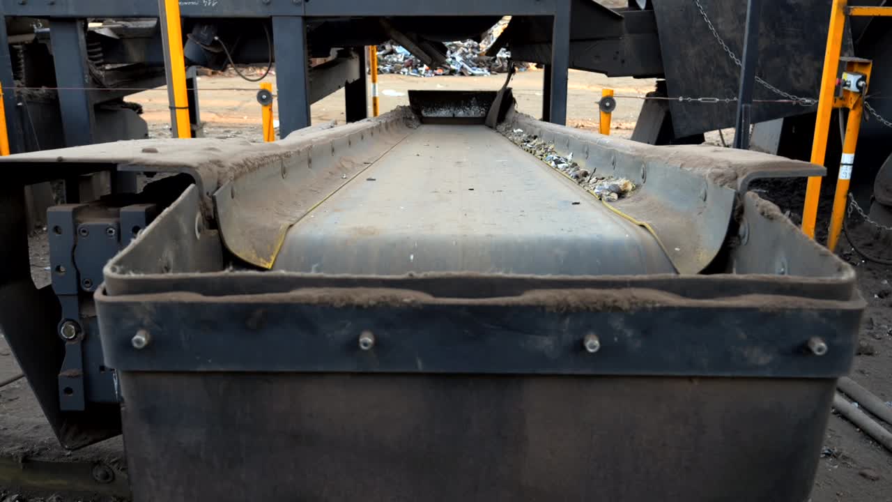 máquina trituradora de automóviles en funcionamiento, primer plano de la cinta transportadora