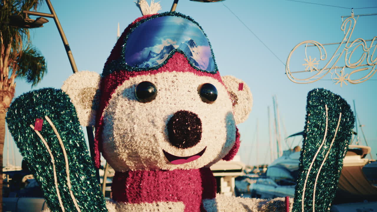 A colorful winter themed polar bear statue with skis stands in a marina decorated for the holidays