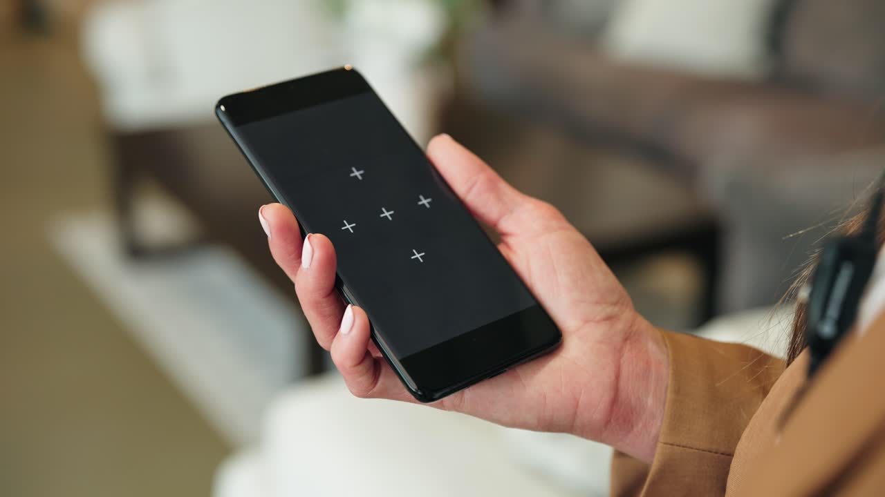 Blazer-wearing woman holds phone with markers while working