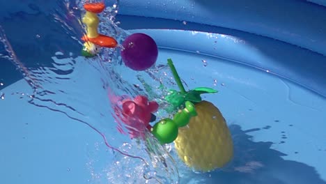 toys and a plastic pineapple falling on a pool