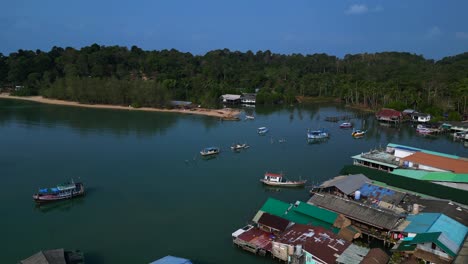 bang bao pier floating village in koh chang island, thailand, showing colorful houses and boats sailing in turquoise water. lovely aerial view flight speed ramp hyper motion time lapse