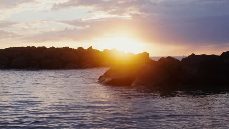 puesta de sol sobre el océano con rocas