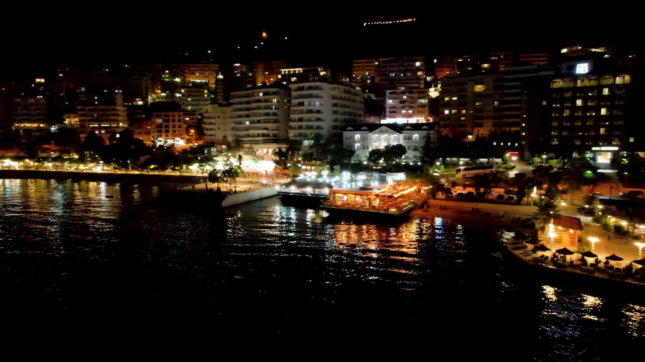 Night Magic at Saranda: Anchored Ships, Illuminated Pier Lights, and a Bustling Promenade Paint a Stunning Picture of Coastal Tourism