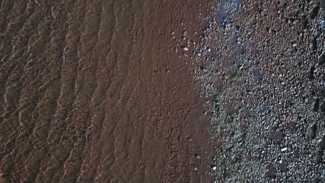 aérea sobre la orilla del lago, pequeñas olas están salpicando sobre las orillas del lago, concepto de naturaleza clara e intacta