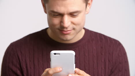 Studio-Shot-Of-Man-Sending-Text-Message-On-White-Background