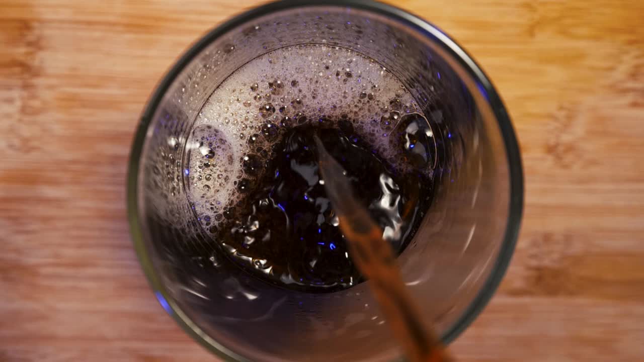 Versando caffè tostato scuro in un bicchiere, creando un’atmosfera intensa e invitante