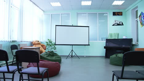 classroom with projector, chairs, and piano