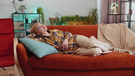 tired lazy woman enjoy relaxing on home sofa resting napping after hard working day, closed her eyes