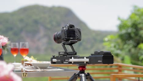 A Canon Camera on A motion slider shooting a meal setup at a hotel restaurant in Thailand