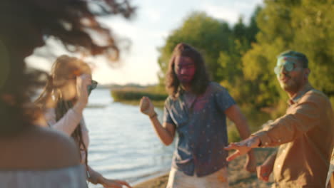 friends celebrating holi by the lake