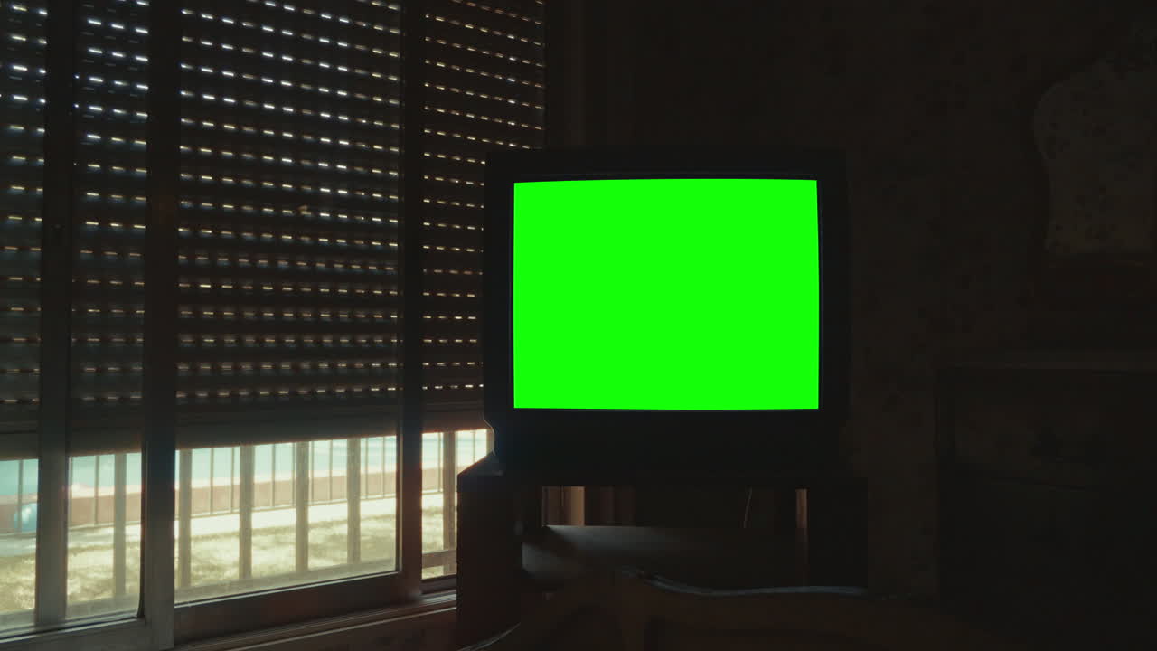 Old CRT Television with Green Screen in Dark Room