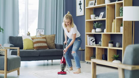 a happy young woman vacuuming the living room