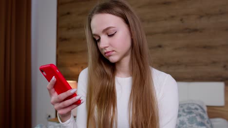 la chica mira la pantalla de su teléfono inteligente hace un pedido en línea exitoso, navega lentamente, navega en línea