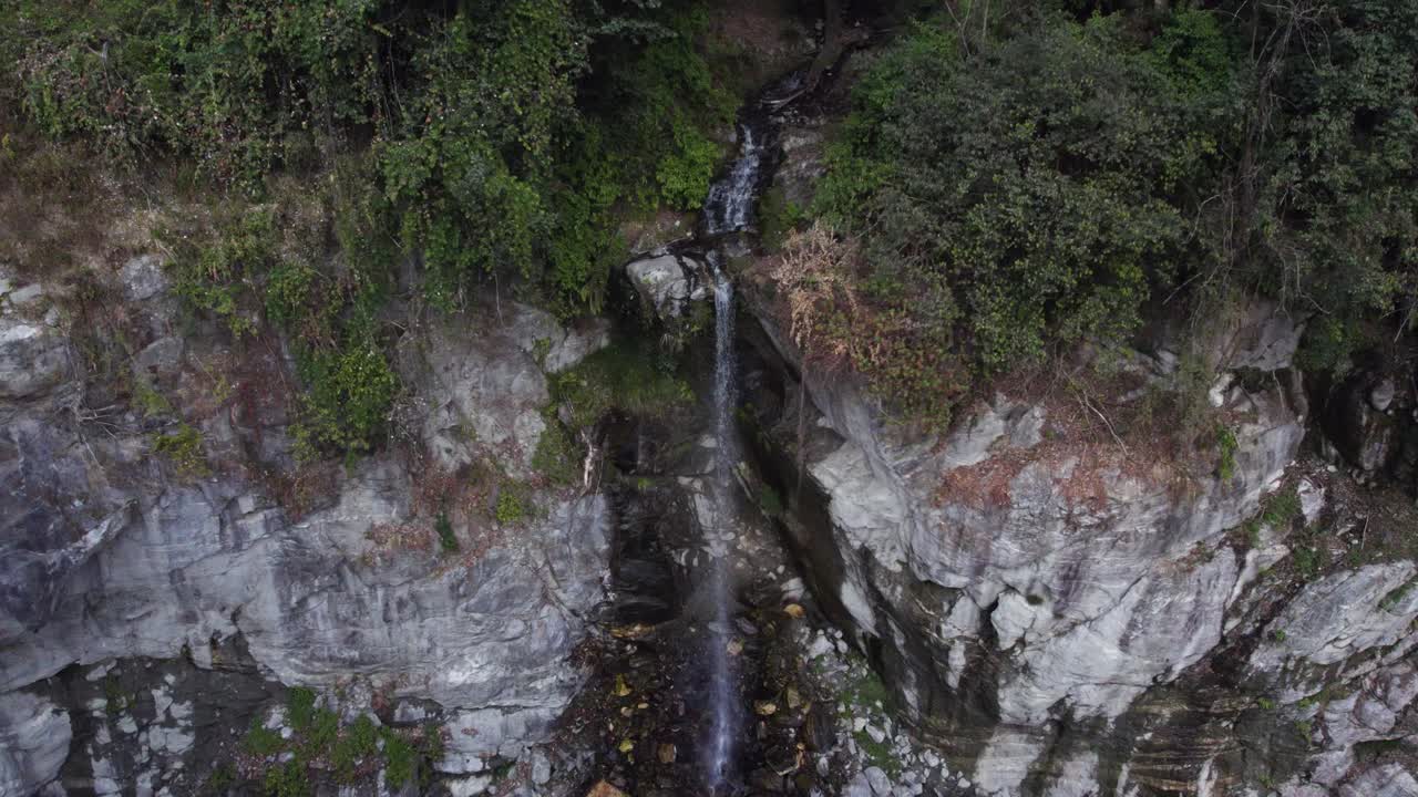 toma aérea de una pequeña cascada que sale de las rocas, pueblo de helambu chofku, nepal
