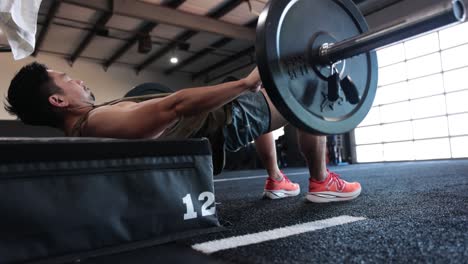 Asian-male-in-gym-performing-hip-thrust-exercise