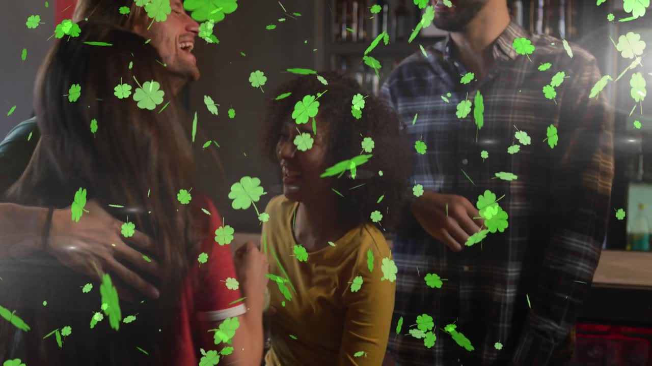 Animation of st patrick's day green shamrock falling over diverse friends having fun at party