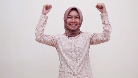 Young-cheerful-excited-asian-muslim-girl-rejoice-success-fist-hands-awesome-isolated-on-white-background