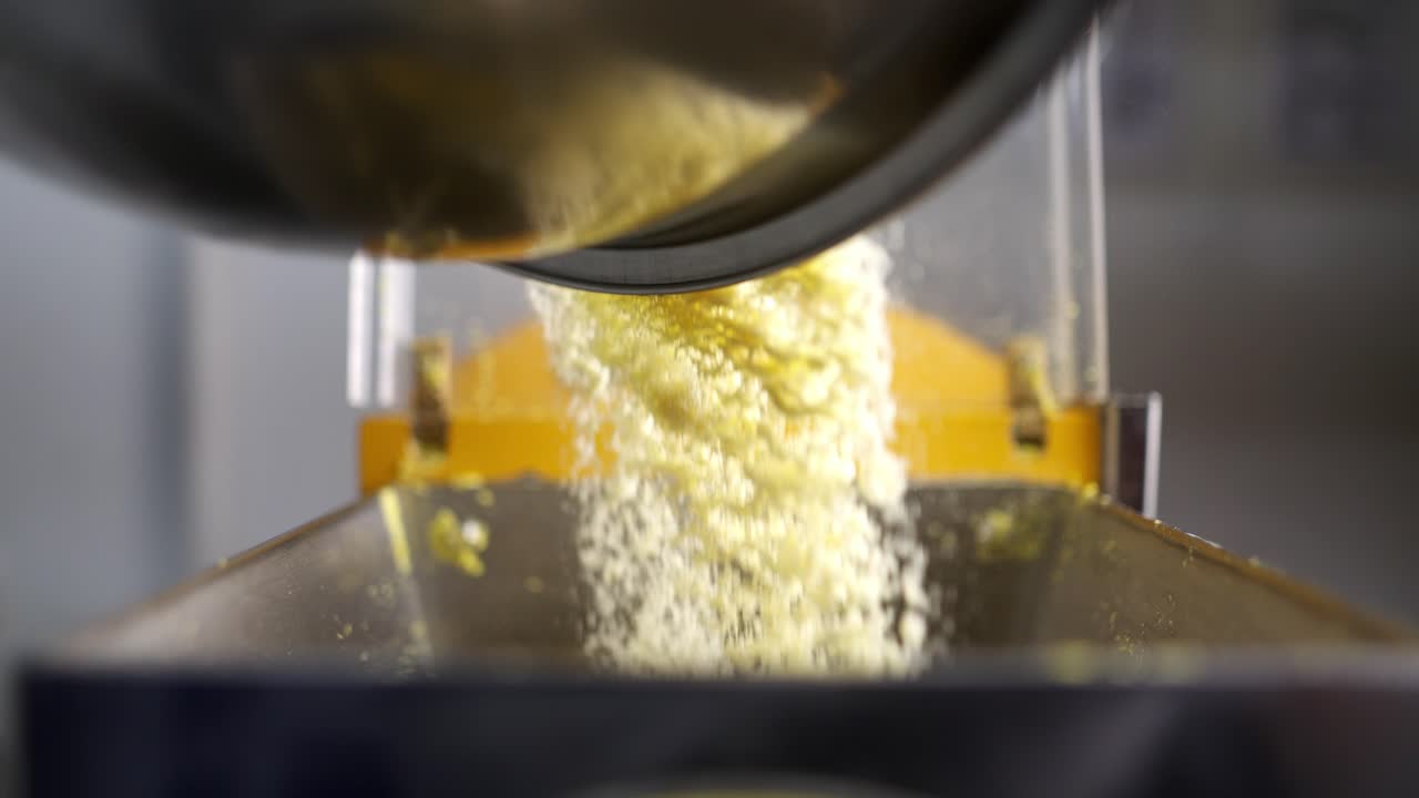 Close up view in slow motion of an unique and creative angle of flour mixing and adding to pasta maker