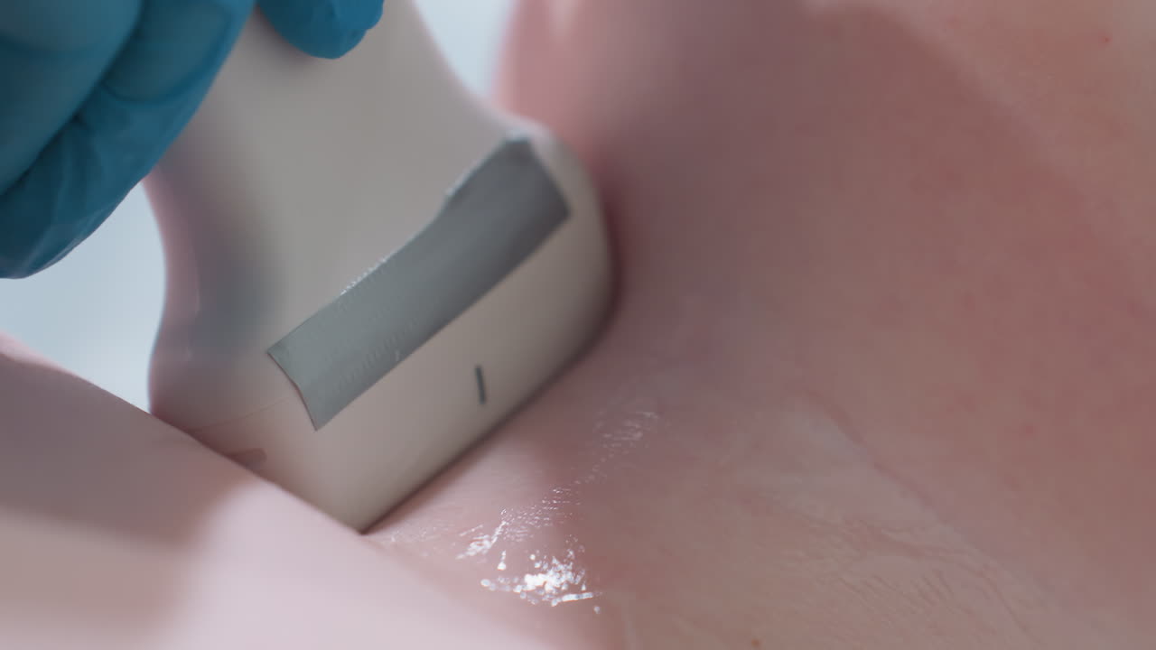 Close up of gel-coated ultrasound transducer gently pressed against patient skin during diagnostic procedure, highlighting precision and care in clinical examination setup for accurate