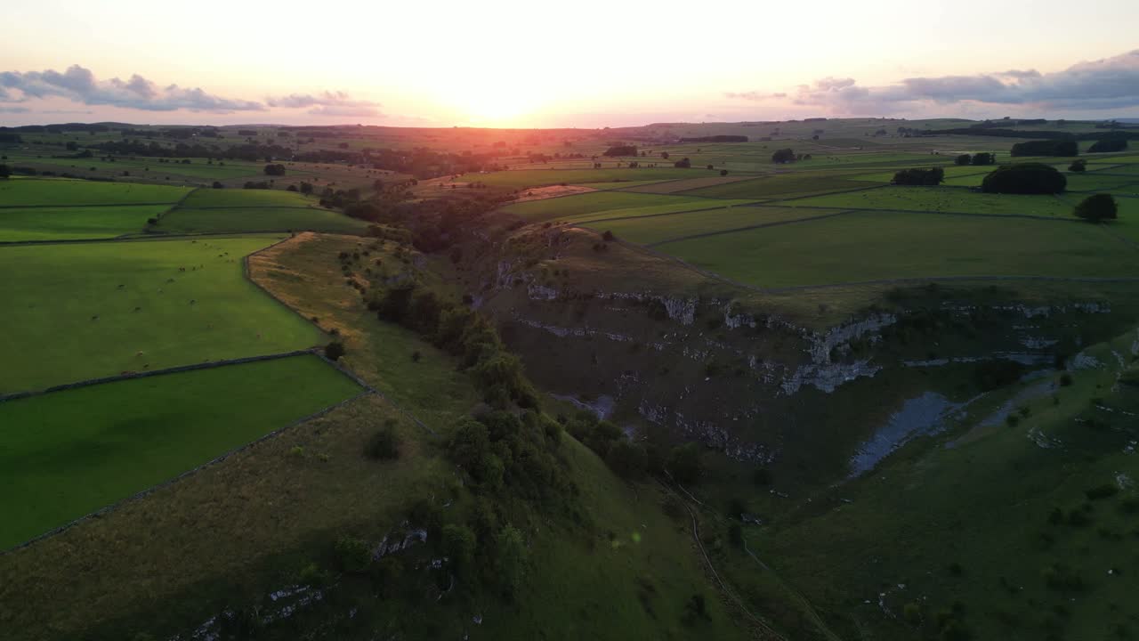 Beautiful Lathkill Dale - drone flies towards the golden sunset, The Peak District, Derbyshire, UK - valley top