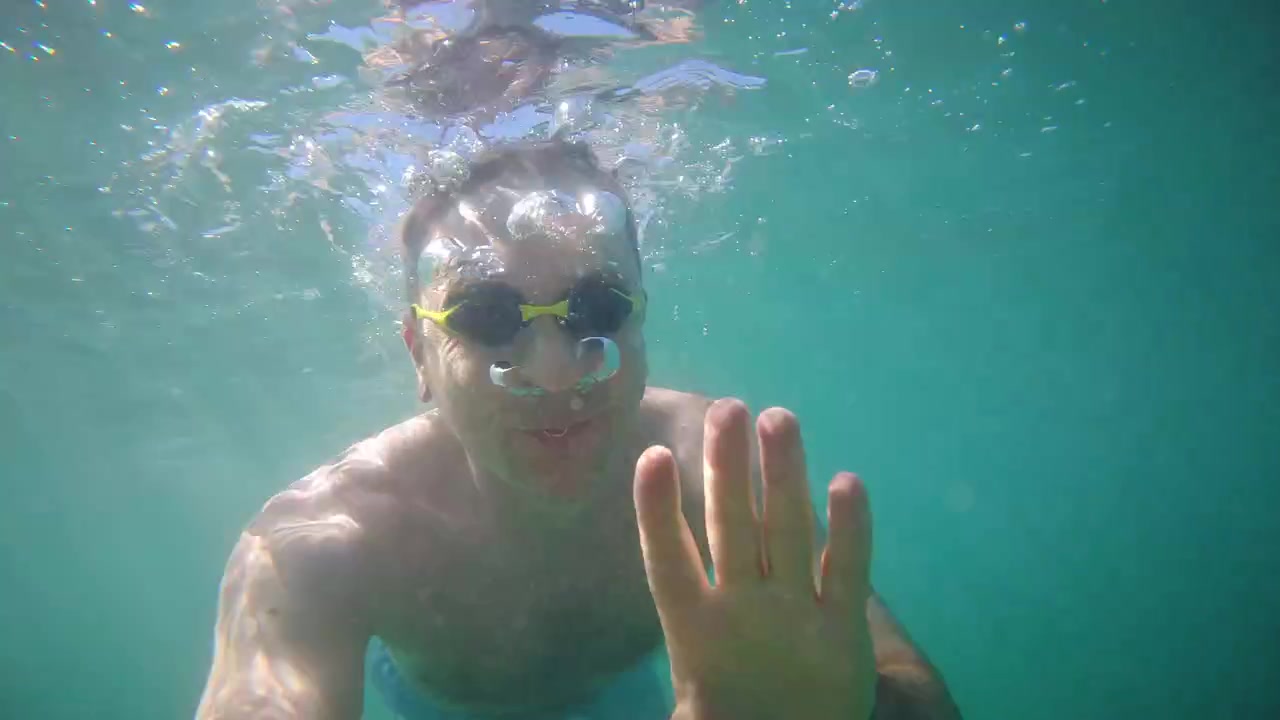 Vista cinematográfica submarina de un nadador haciendo snorkel en aguas marinas azules y cristalinas durante las vacaciones de verano