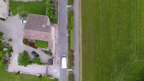 birds-eye-view tracking shot of a white good van traveling through the countryside