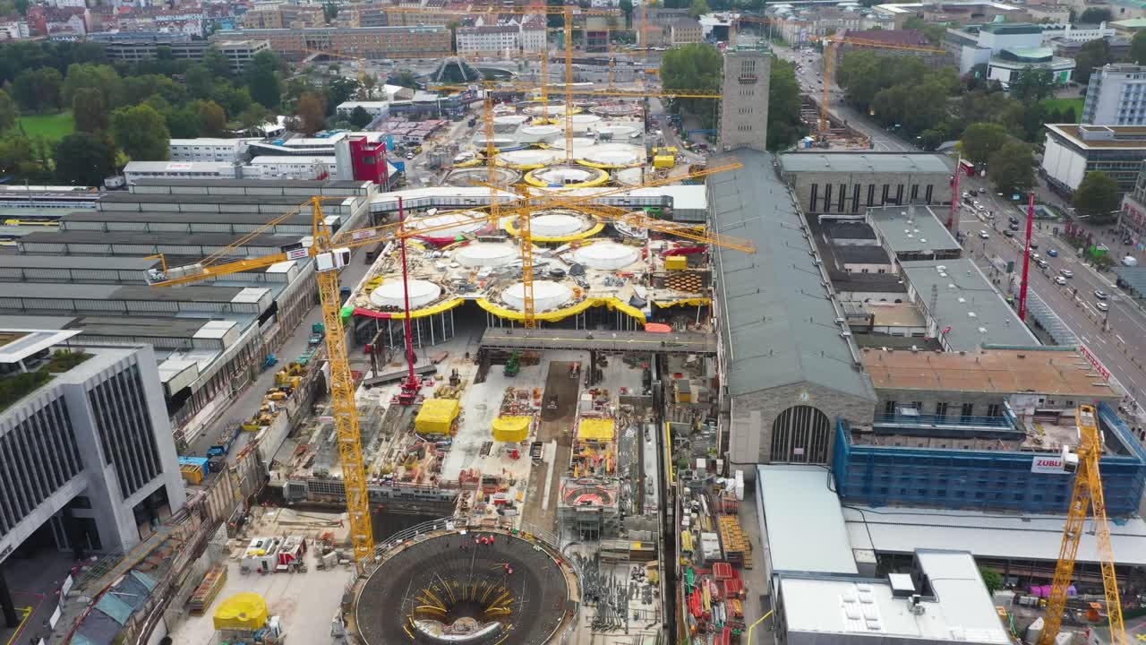 drone volando sobre un enorme sitio de construcción de la estación de tren principal stuttgart s21 con grúas y trabajadores de la construcción en stuttgart, alemania