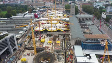 drone flying over huge construction site of main train station stuttgart s21 with cranes and construction workers in stuttgart, germany