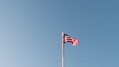 american flag fluttering against blue sky