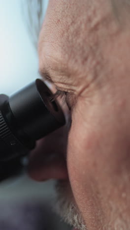 man using a microscope