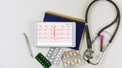cardiograph ekg electrocardiogram heart showing in tablet with medical documents on desk of doctor
