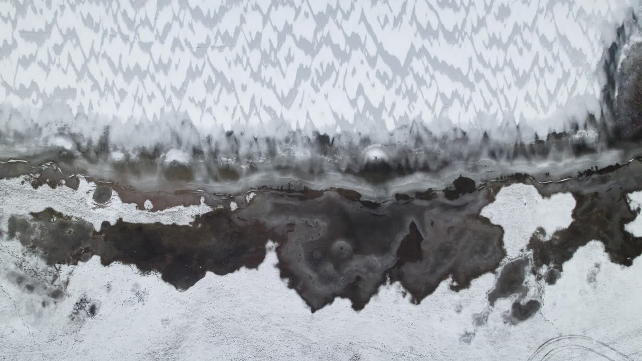 Panoramica dall'alto di un lago ghiacciato con motivo a spina di pesce di neve a Suwałki Gap, Masuria, Polonia, ripresa aerea