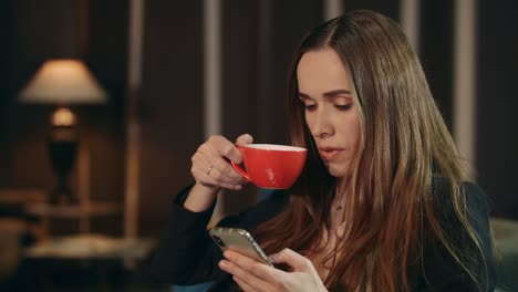 business woman using smartphone at home. businesswoman drinking tea