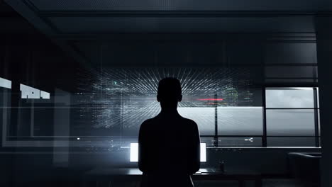 silhouette of a person in front of a computer screen displaying data