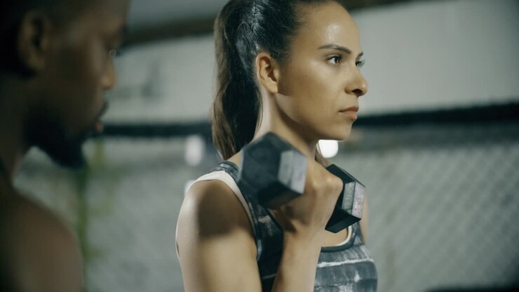 Frau trainiert mit Personal Trainer im Fitnessstudio